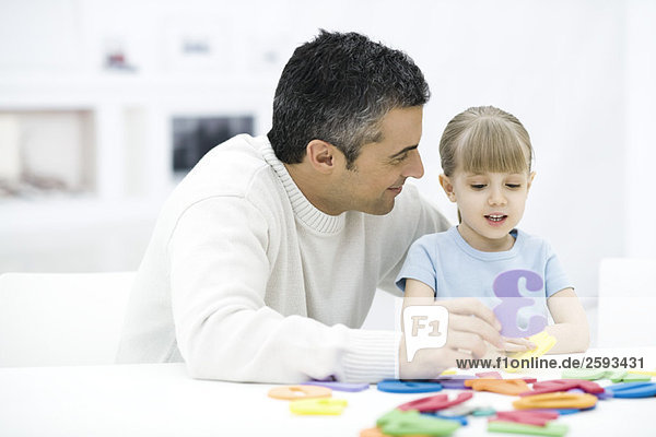 Vater und junge Tochter lernen gemeinsam Zahlen