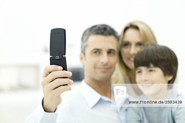 Familie  die gemeinsam auf das Handy schaut  konzentriert sich auf das Telefon.