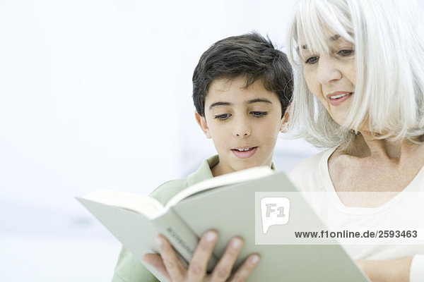 Großmutter und Enkel lesen gemeinsam Buch