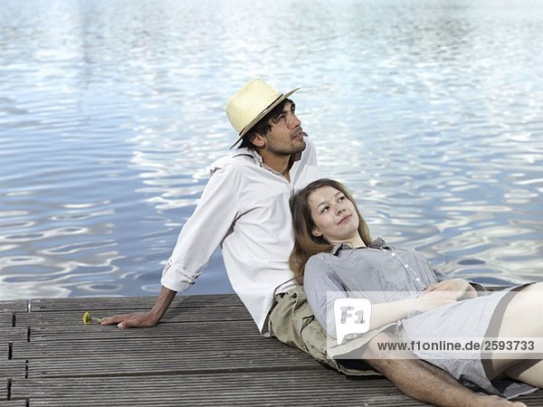 A young couple sitting on a jetty