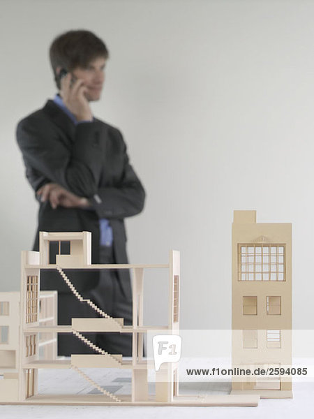Architectural models and a business man standing in the background