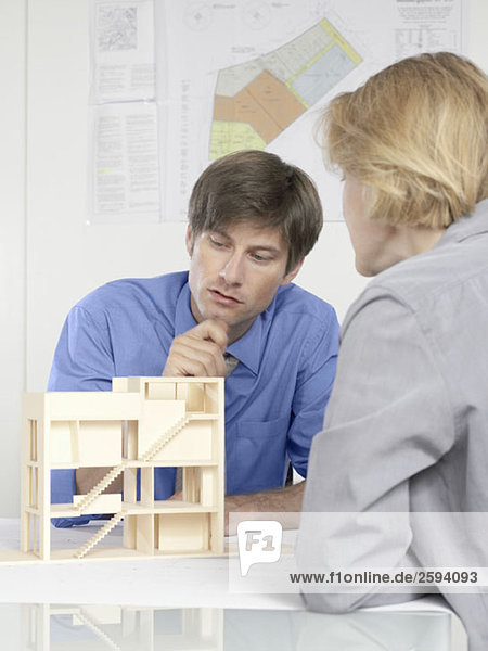 Two people discussing an architectural model