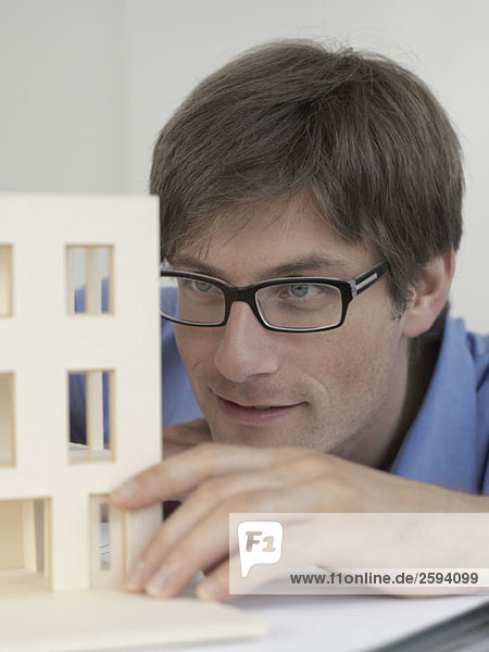 An architect examining an architectural model