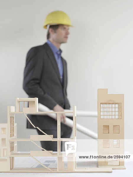 An architect standing behind an architectural model