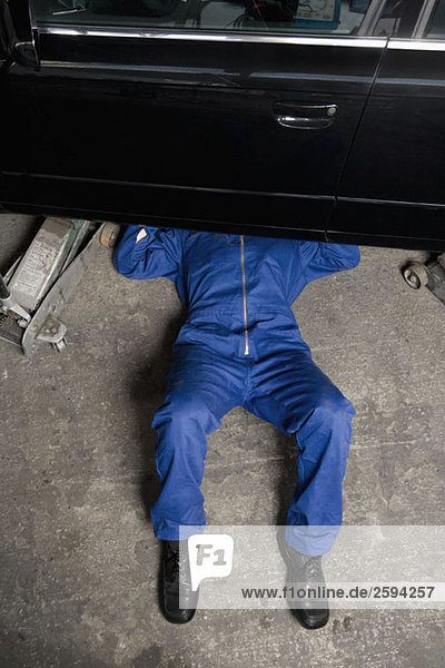 A car mechanic servicing a car