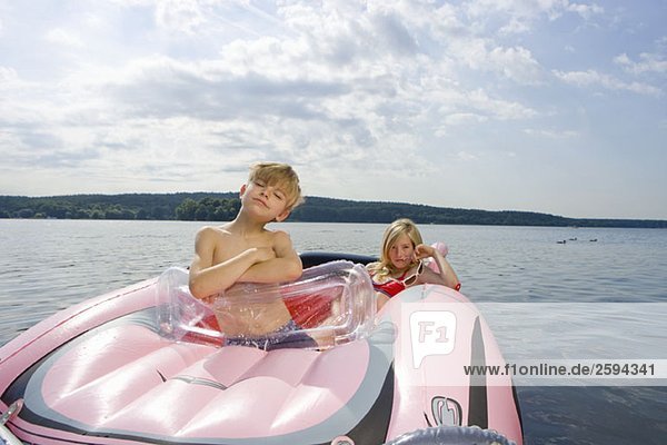 Zwei Kinder in einem Schlauchboot auf einem See