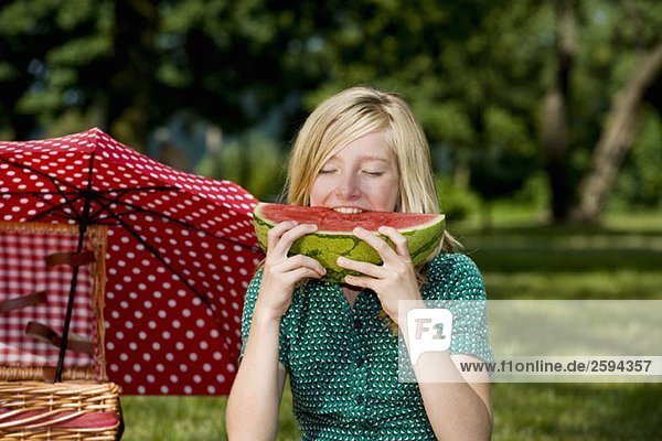 Ein Mädchen  das eine Scheibe Wassermelone isst.