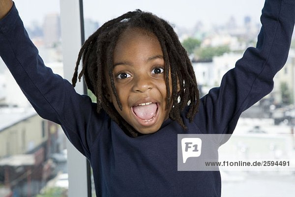 A young boy with his arms raised in excitement