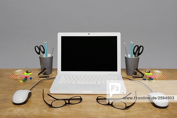 Laptop und Briefpapier auf einem Schreibtisch angeordnet