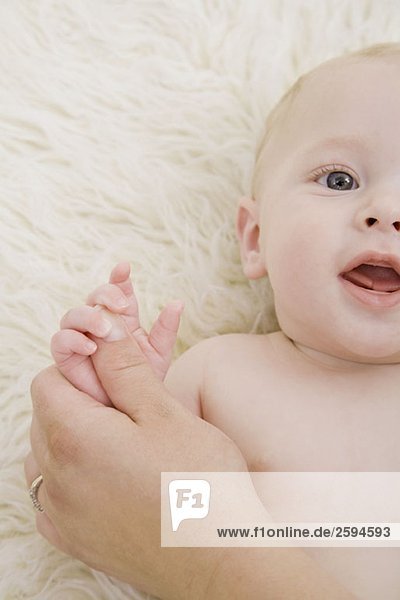 Eine menschliche Hand  die die Hand eines Babys hält.