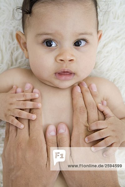 menschliche Hände  die ein Baby trösten