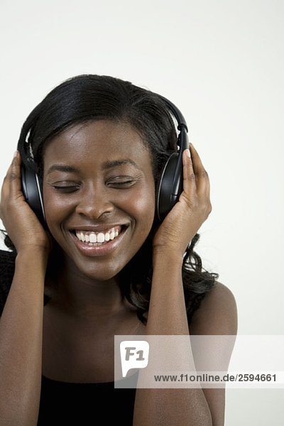 Eine Afroamerikanerin  die Kopfhörer hört.