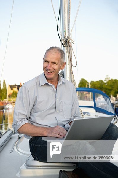 Mann auf dem Boot mit Computer