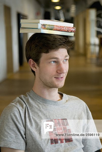 Guy Balancing Bücher auf dem Kopf