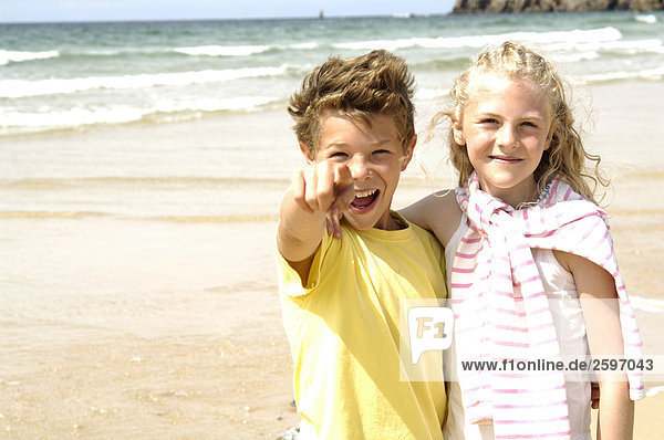 Portrait of boy and girl smiling on beach