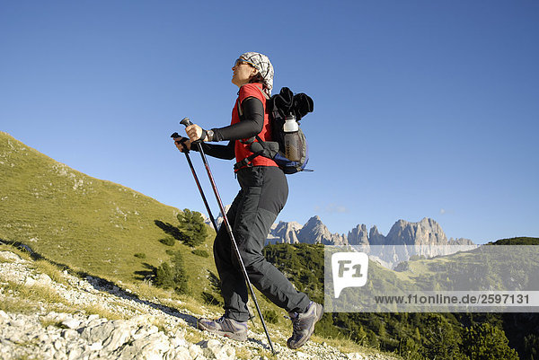Low angle view of female hiker climbing hill  Trentino-Alto Adige  Italy