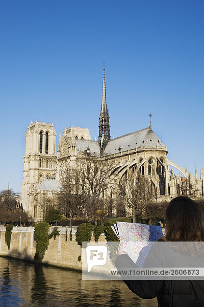 Frau liest Stadtplan vor Seine und Kathedrale von Notre Dame Paris Frankreich
