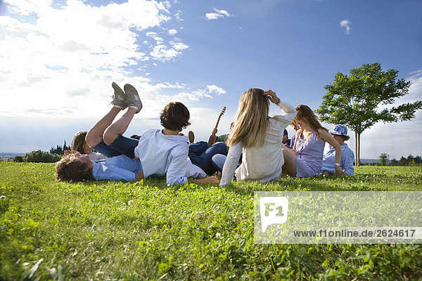 Teenagergruppe auf Gras im Park liegend