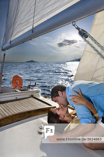 Paar auf Segelboot liegend  küssend
