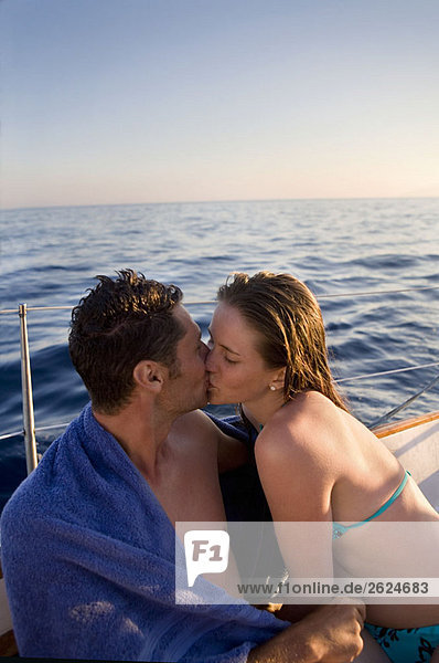 Junges Paar  das sich auf einem Segelboot küsst