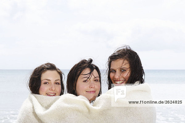 Drei Mädchen  die sich eine Decke teilen