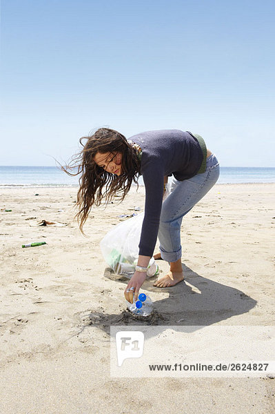 Junges Mädchen sammelt Müll am Strand