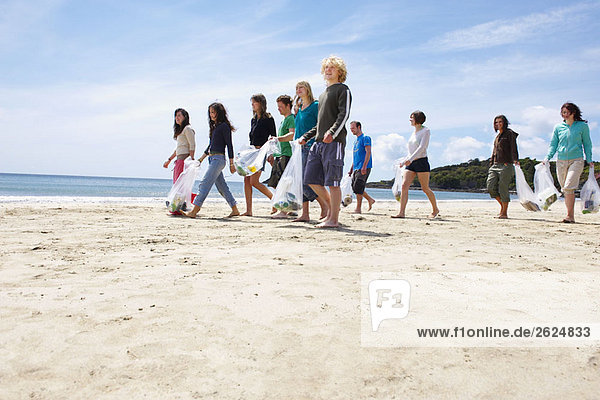 Junge Leute sammeln Müll am Strand