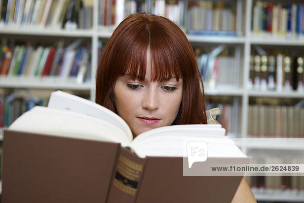 Young woman reading in library