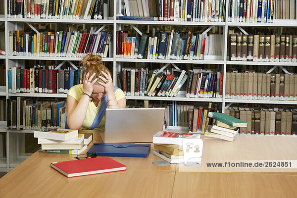 Despairing young woman in library