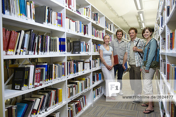 Vier junge Studenten in einer Bibliothek