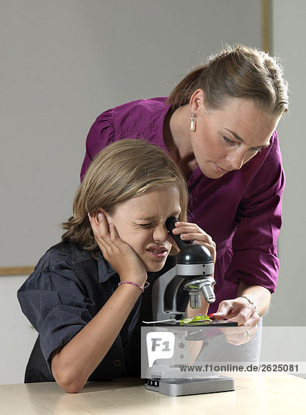 Lehrer und Schüler mit dem Mikroskop
