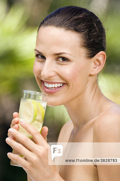 Young woman in bikini holding lemon drink