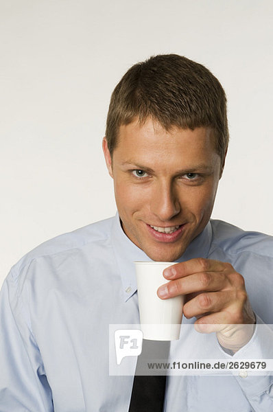 Geschäftsmann hält Tasse Kaffee  Porträt