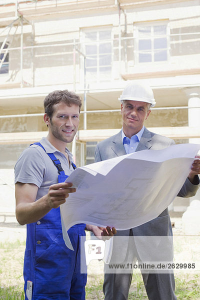 Architekt und Bauarbeiter mit Bauplan