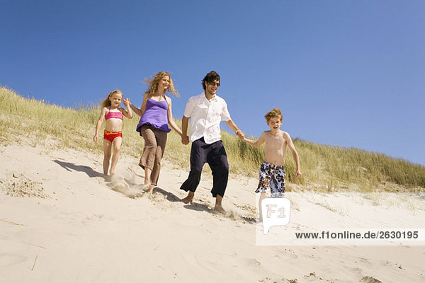 Germany  Baltic sea  Family running down sand dunes