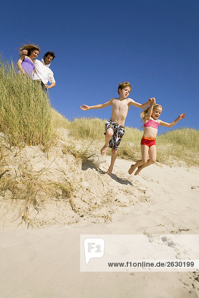 Deutschland  Ostsee  Familie in Sanddünen  Kinder springen über Sanddünen