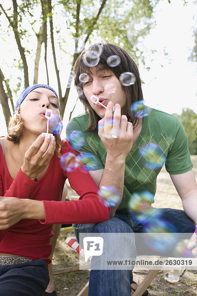 Germany  Young couple blowing bubbles