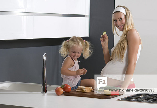Schwangere Mutter und Tochter (3-4) in der Küche