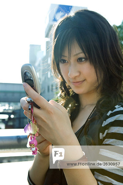 Young Japanese woman looking at cell phone