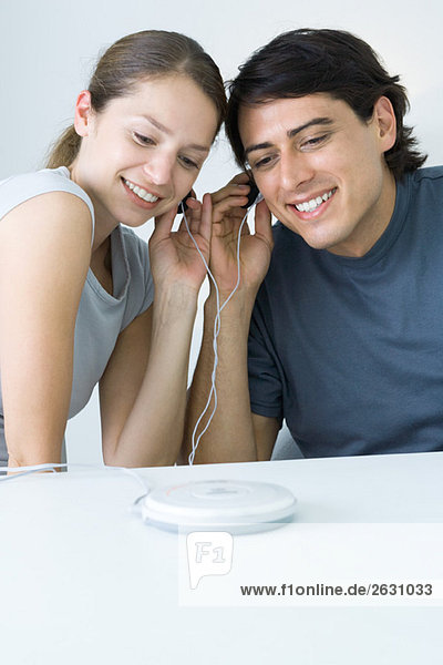 Paare teilen Kopfhörer  hören auf tragbare CD-Player