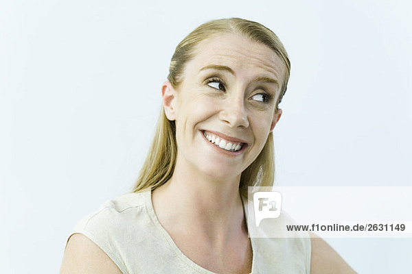 Woman smiling  raising eyebrows  looking away