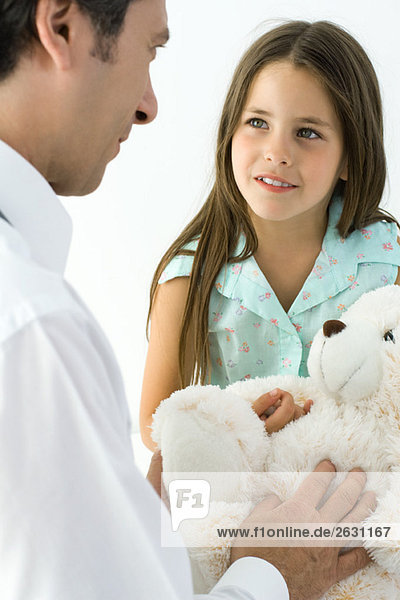 Kinderärztin mit junger Patientin  Mädchen mit Teddybärin