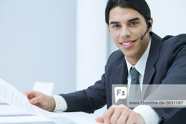 Young professional man wearing headset  smiling at camera  portrait