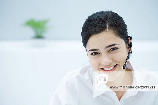 Young woman wearing headset  smiling at camera  portrait