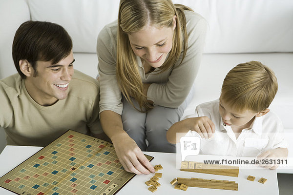 Family playing board game together  mother arranges game pieces