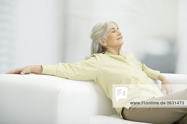 Seniorin entspannt auf der Couch  Augen geschlossen