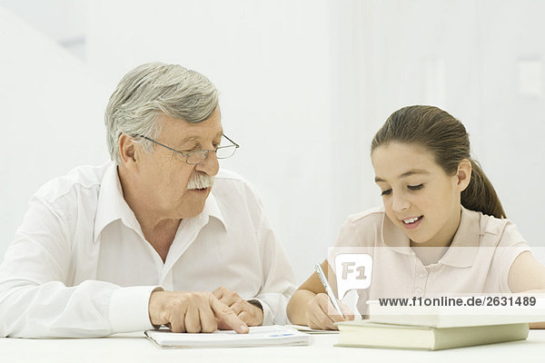 Großvater hilft Enkelin bei den Hausaufgaben