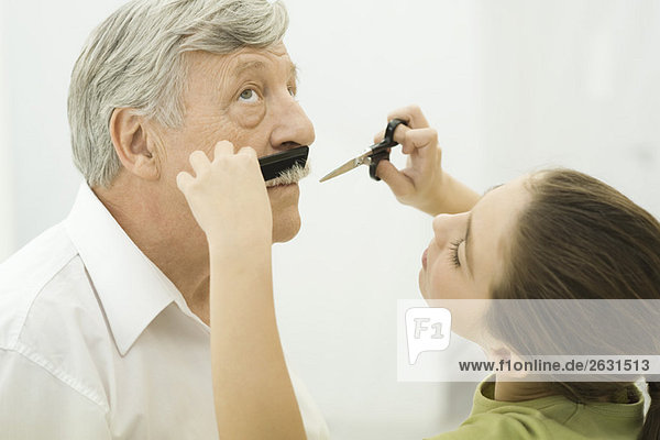 Enkelin trimmt Großvaters Schnurrbart