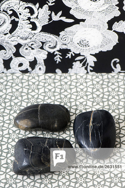 Three polished pebbles arranged against patterned background