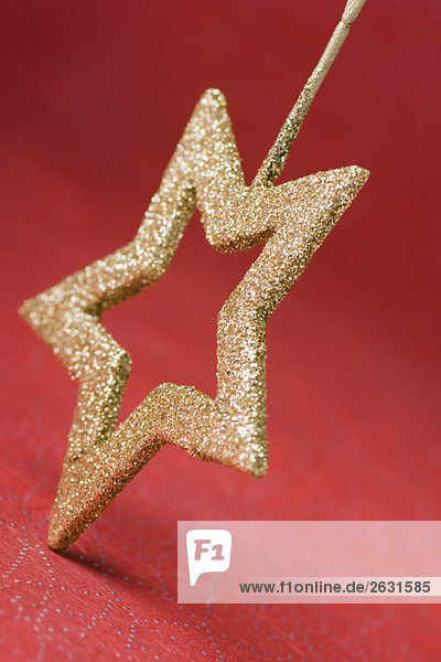 Weihnachtsbaumschmuck in Form eines goldenen Sterns  umgedreht